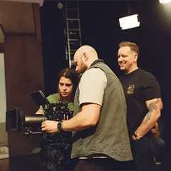 FIlm Crew and Cinematographer gathered around a RED cinema camera while on set