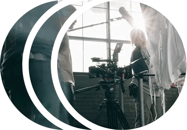 A film crew preparing for a shot with a RED cinema camera on a tripod