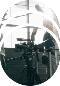 A film crew preparing for a shot with a RED cinema camera on a tripod