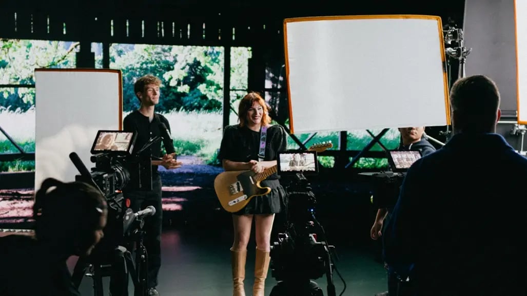 A musician filming a music video in front of an LED wall in a virtual production studio