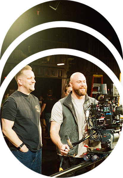 A director watches as a cinematographer operates a RED cinema camera with a REDSPY camera tracker on it