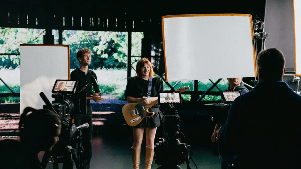Two musicians filming a music video stand in front of an LED wall at a virtual production studio