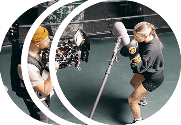 A boxer in the ring is preparing for a fight while a cinematographer films her on a RED cinema camera