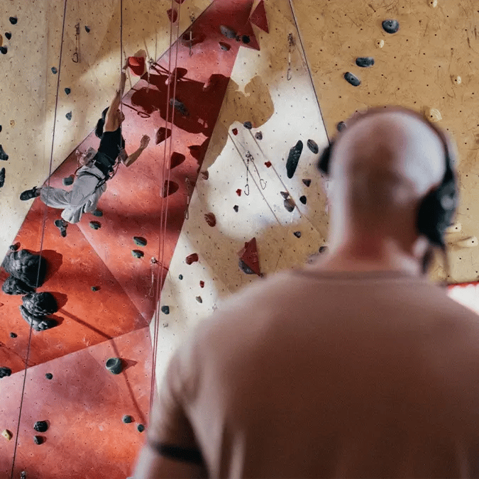 A cinematographer films a rock climber